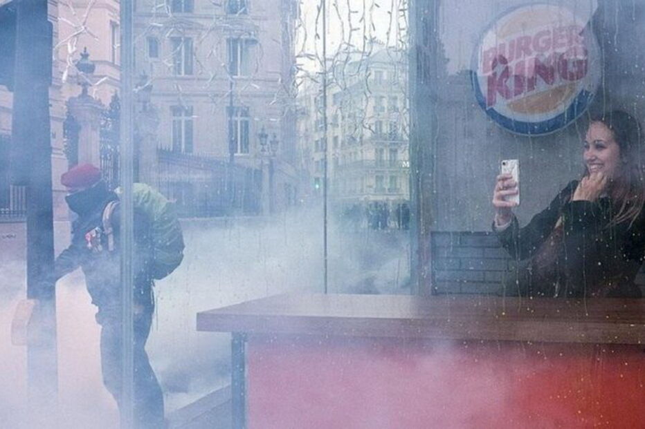 Mulher tira 'selfie' sorridente no meio dos protestos em França