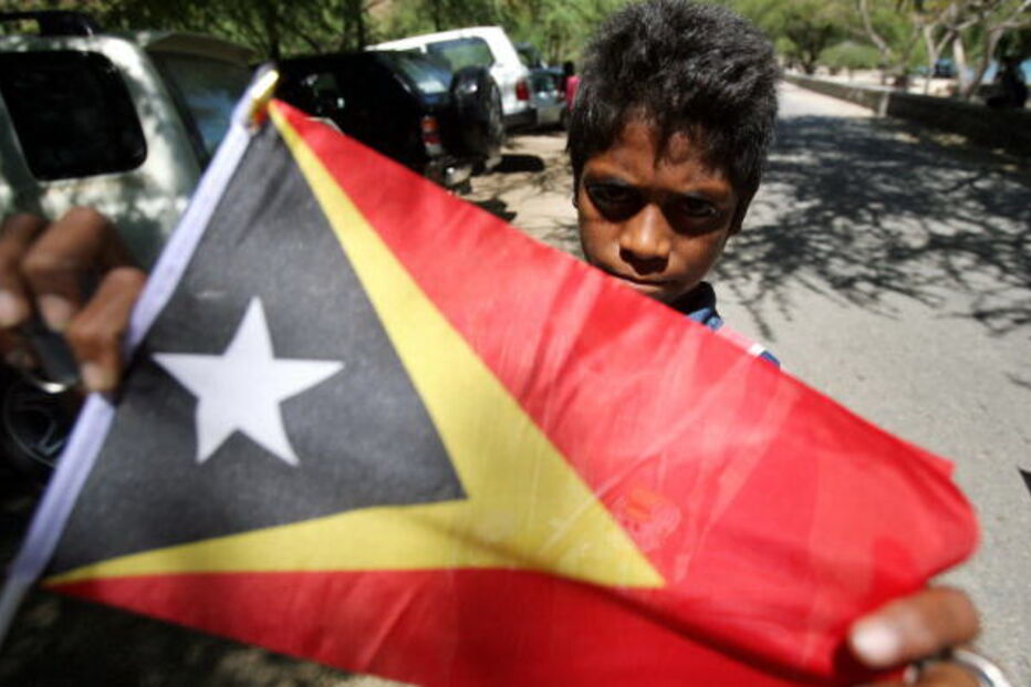Criança com a bandeira de Timor-Leste