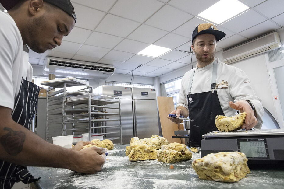 O proprietário do estabelecimento auxilia na confeção do Bolo Rei