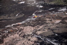 Pessoas e animais entre rios de lama causados pela rutura de barragem no Brasil