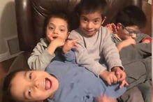 Menino com síndrome de down ajuda irmãos deficientes a comer e a vestir