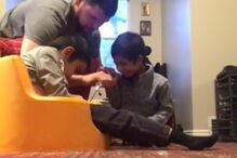 Menino com síndrome de down ajuda irmãos deficientes a comer e a vestir