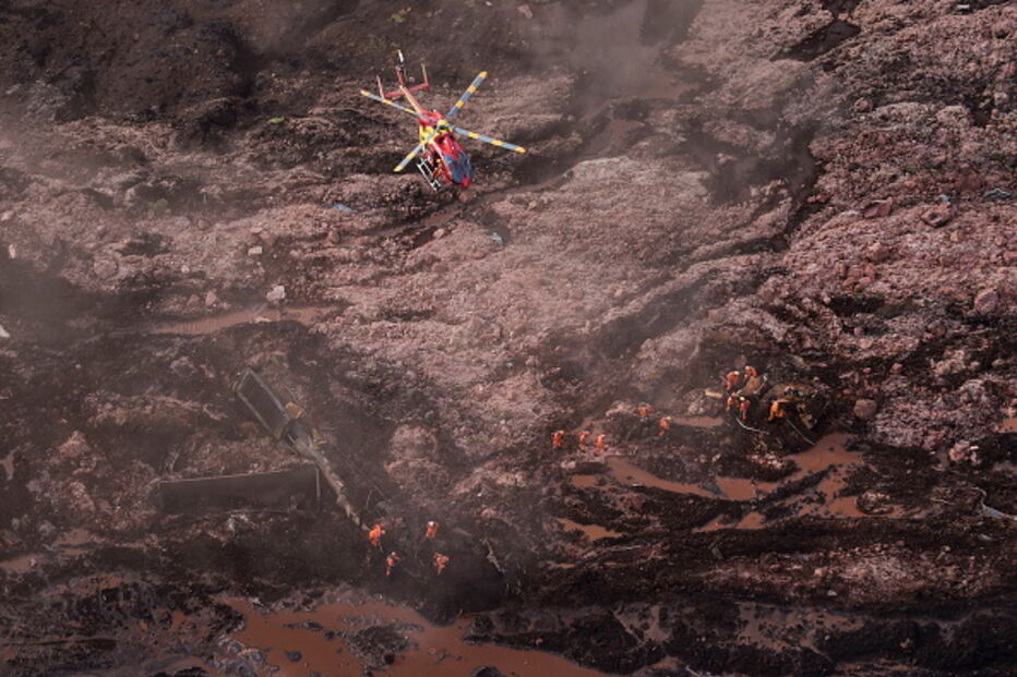 Pessoas e animais entre rios de lama causados pela rutura de barragem no Brasil