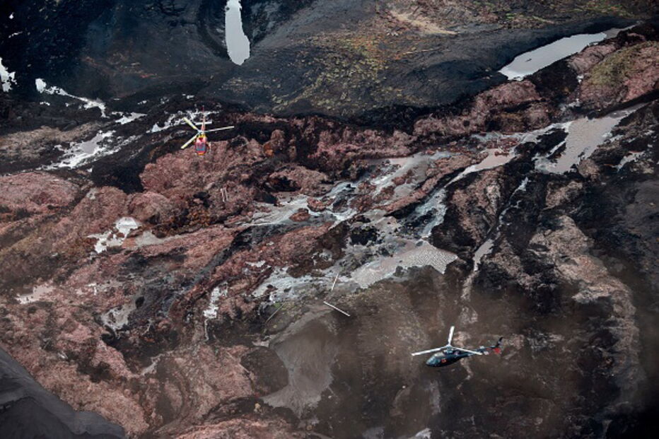 Pessoas e animais entre rios de lama causados pela rutura de barragem no Brasil