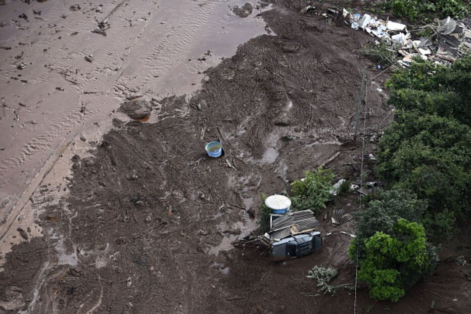 Pessoas e animais entre rios de lama causados pela rutura de barragem no Brasil