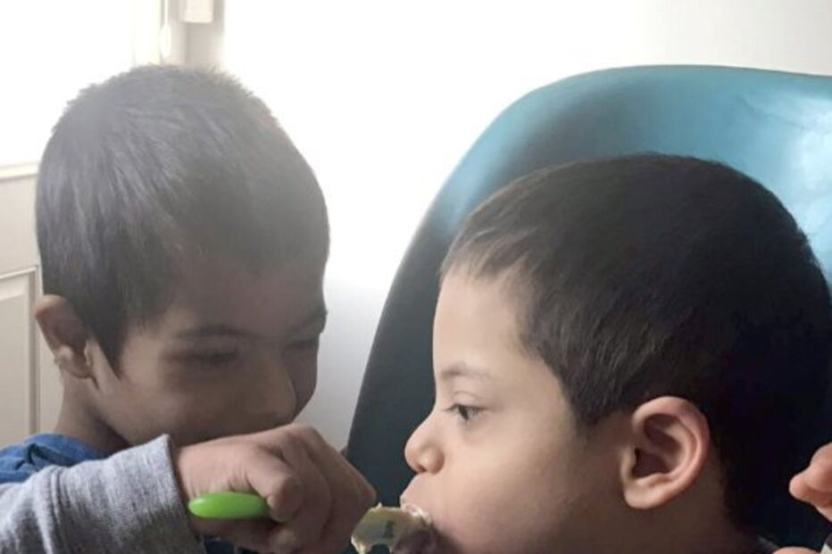 Menino com síndrome de down ajuda irmãos deficientes a comer e a vestir