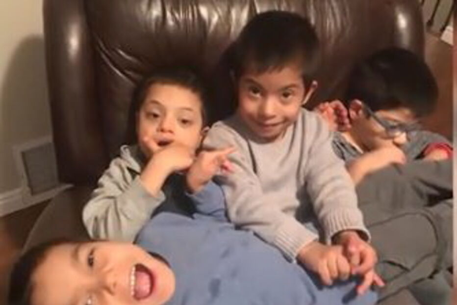 Menino com síndrome de down ajuda irmãos deficientes a comer e a vestir