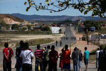 Manifestantes venezuelanos em confrontos com membros do Exército junto à fronteira com o Brasil