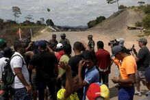 Manifestantes venezuelanos em confrontos com membros do Exército junto à fronteira com o Brasil