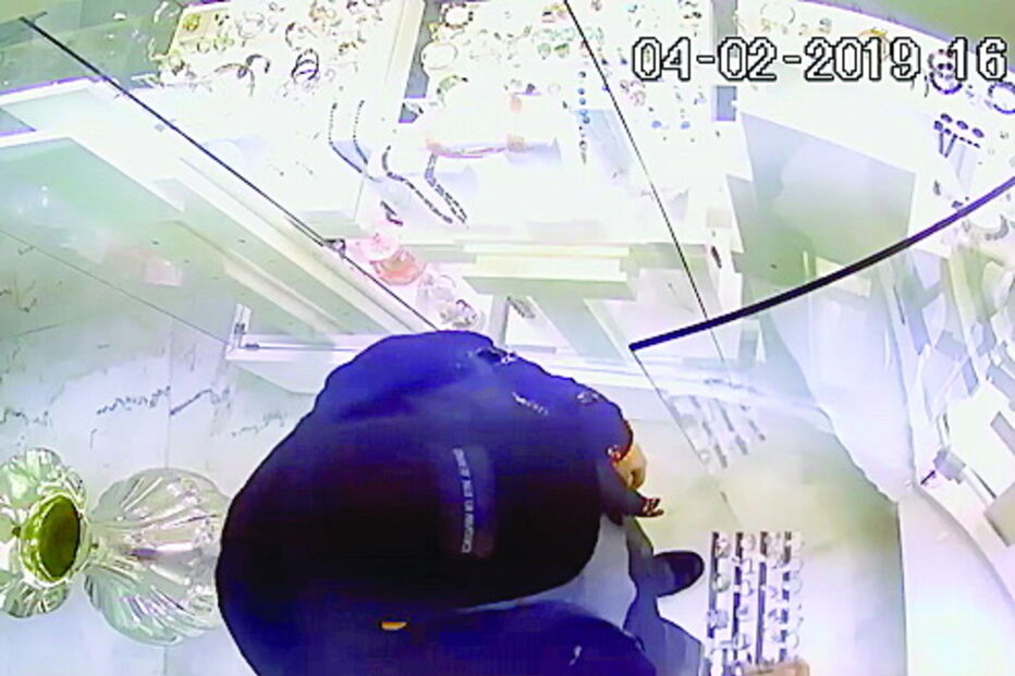 Momento em que assaltante retira anéis da montra