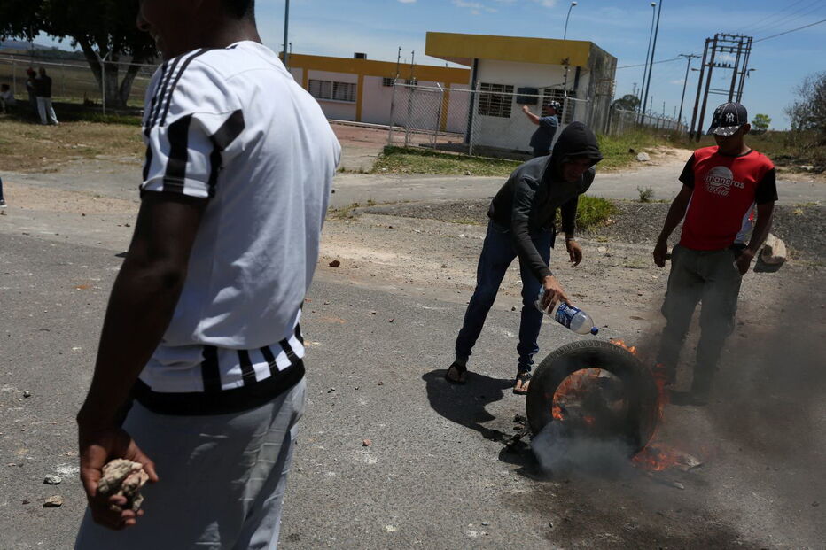Manifestantes venezuelanos em confrontos com membros do Exército junto à fronteira com o Brasil