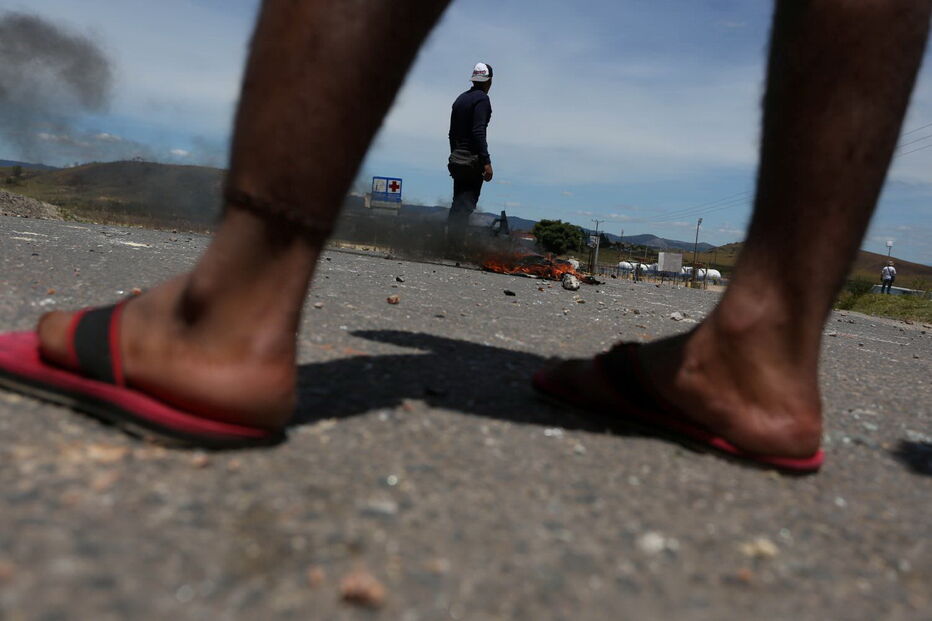 Manifestantes venezuelanos em confrontos com membros do Exército junto à fronteira com o Brasil