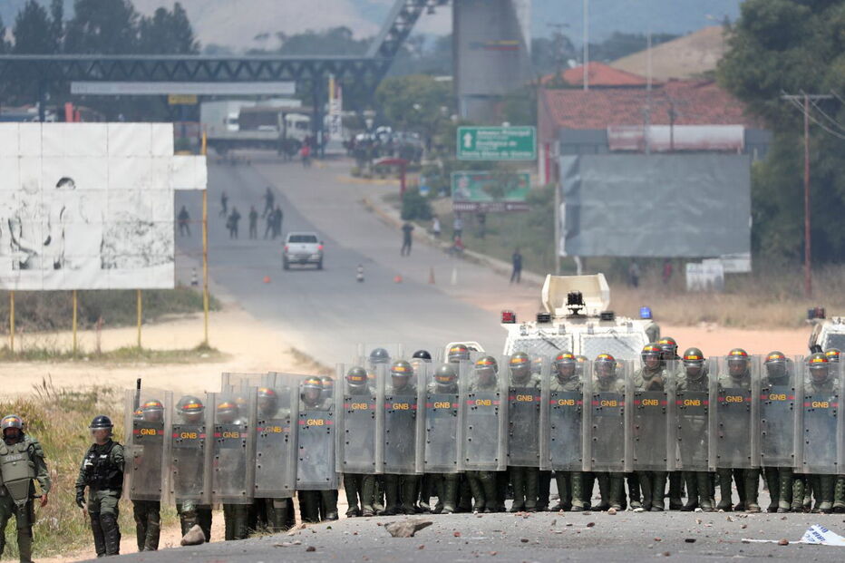 Manifestantes venezuelanos em confrontos com membros do Exército junto à fronteira com o Brasil