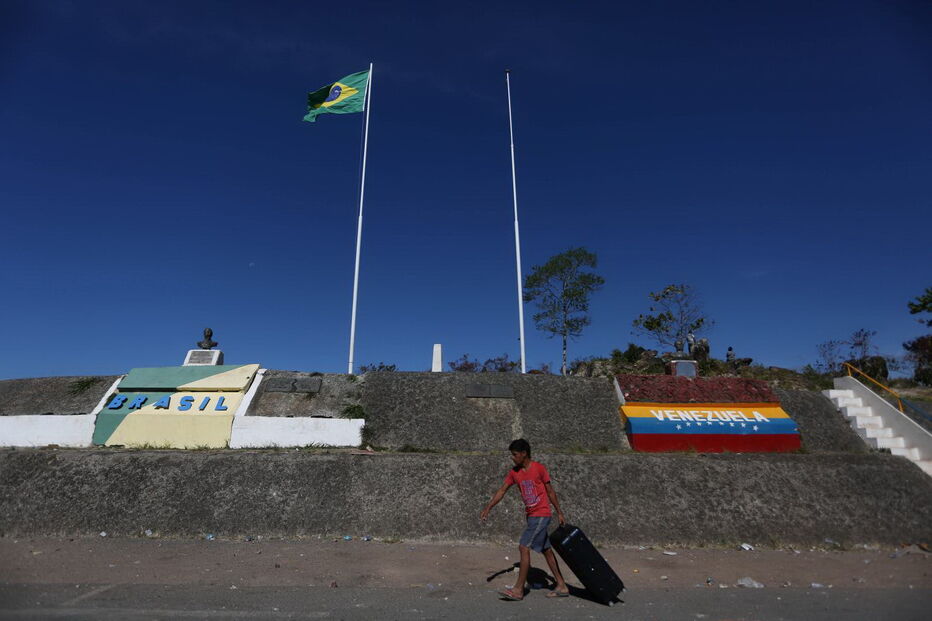 Manifestantes venezuelanos em confrontos com membros do Exército junto à fronteira com o Brasil