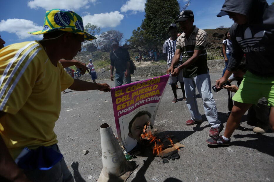Manifestantes venezuelanos em confrontos com membros do Exército junto à fronteira com o Brasil