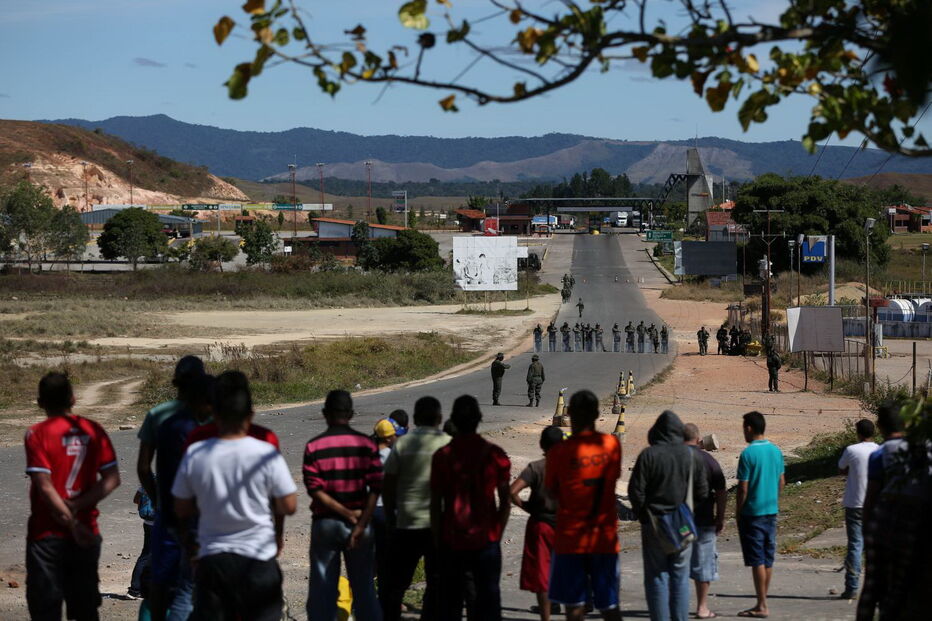 Manifestantes venezuelanos em confrontos com membros do Exército junto à fronteira com o Brasil