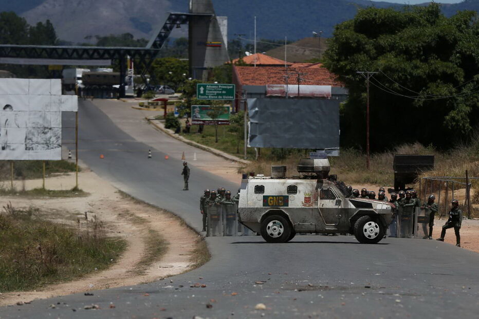 Manifestantes venezuelanos em confrontos com membros do Exército junto à fronteira com o Brasil