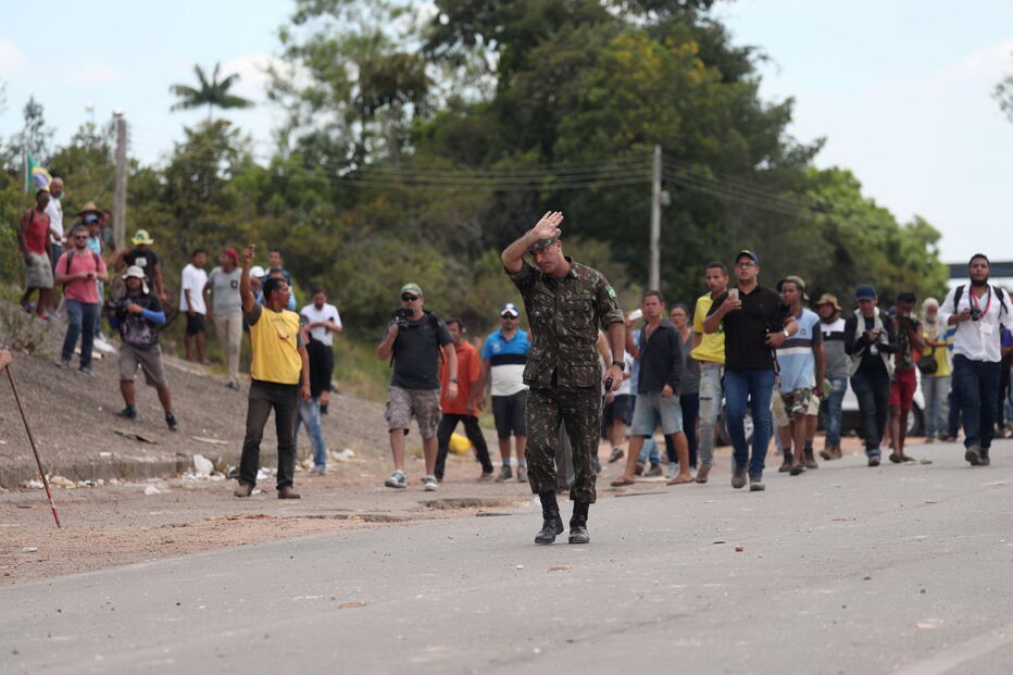Manifestantes venezuelanos em confrontos com membros do Exército junto à fronteira com o Brasil