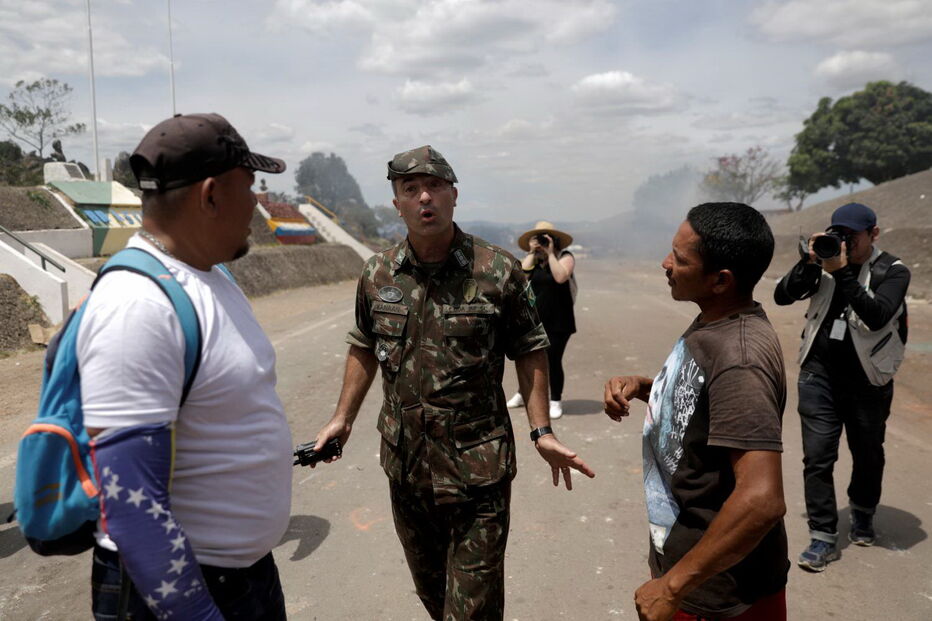 Manifestantes venezuelanos em confrontos com membros do Exército junto à fronteira com o Brasil