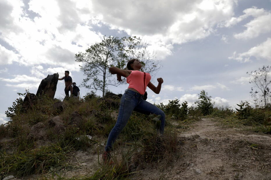Manifestantes venezuelanos em confrontos com membros do Exército junto à fronteira com o Brasil