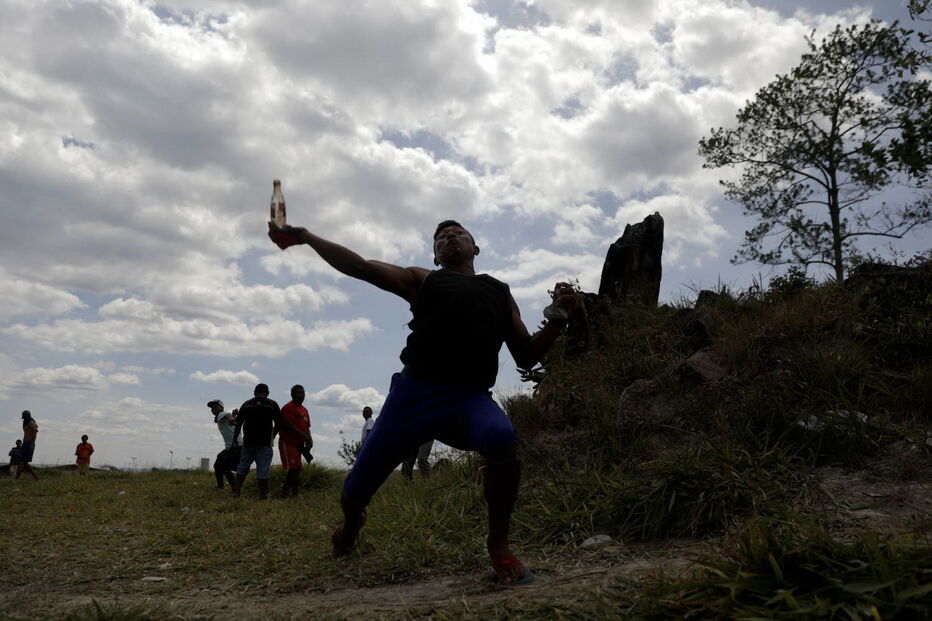 Manifestantes venezuelanos em confrontos com membros do Exército junto à fronteira com o Brasil