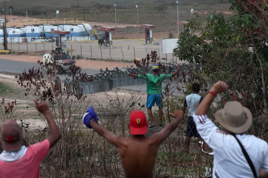 Manifestantes venezuelanos em confrontos com membros do Exército junto à fronteira com o Brasil