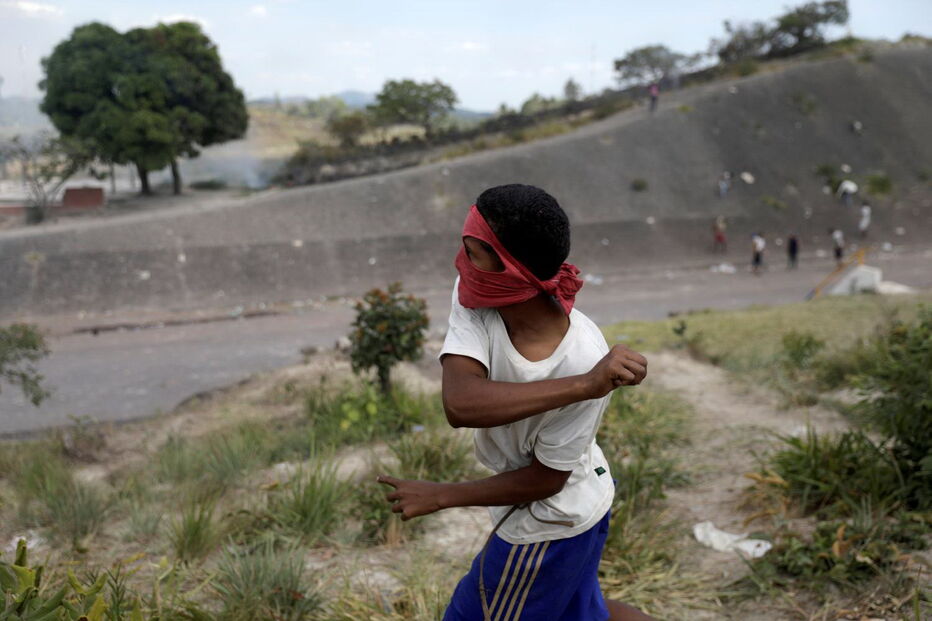 Manifestantes venezuelanos em confrontos com membros do Exército junto à fronteira com o Brasil