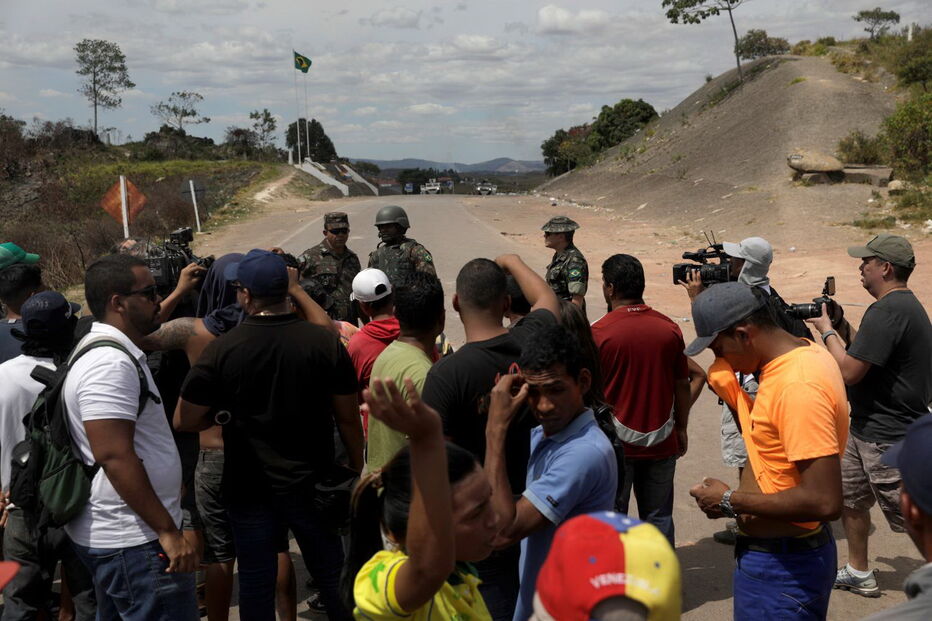 Manifestantes venezuelanos em confrontos com membros do Exército junto à fronteira com o Brasil