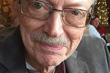 Fotografia mostra cão debruçado sobre o caixão do dono em funeral