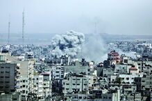 Uma coluna de fumo eleva-se de um edifício atingido em Gaza 