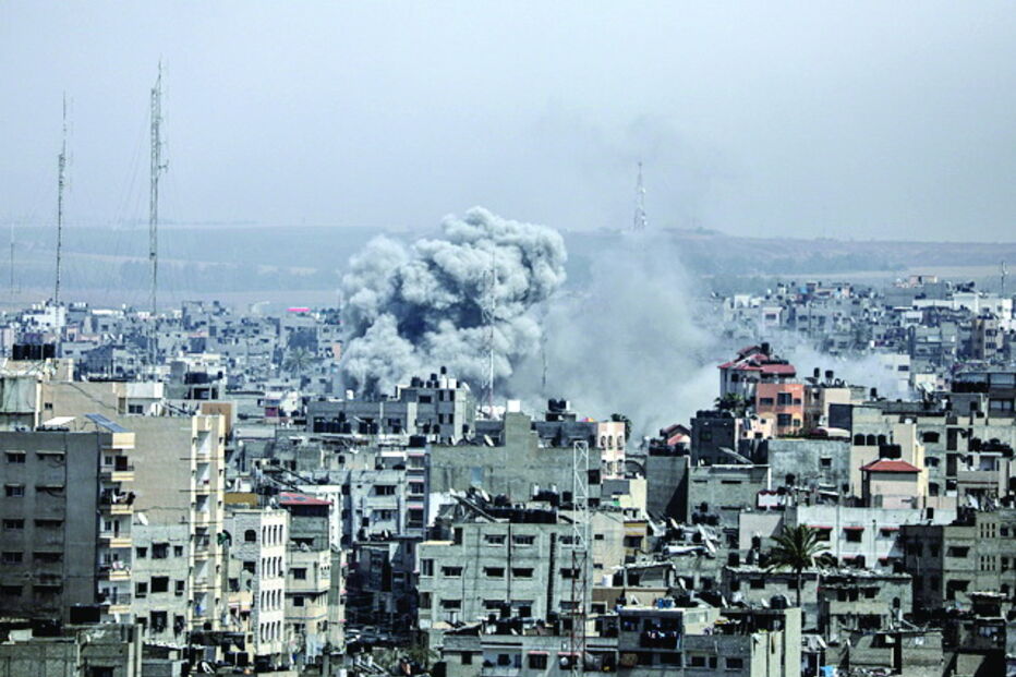 Uma coluna de fumo eleva-se de um edifício atingido em Gaza 
