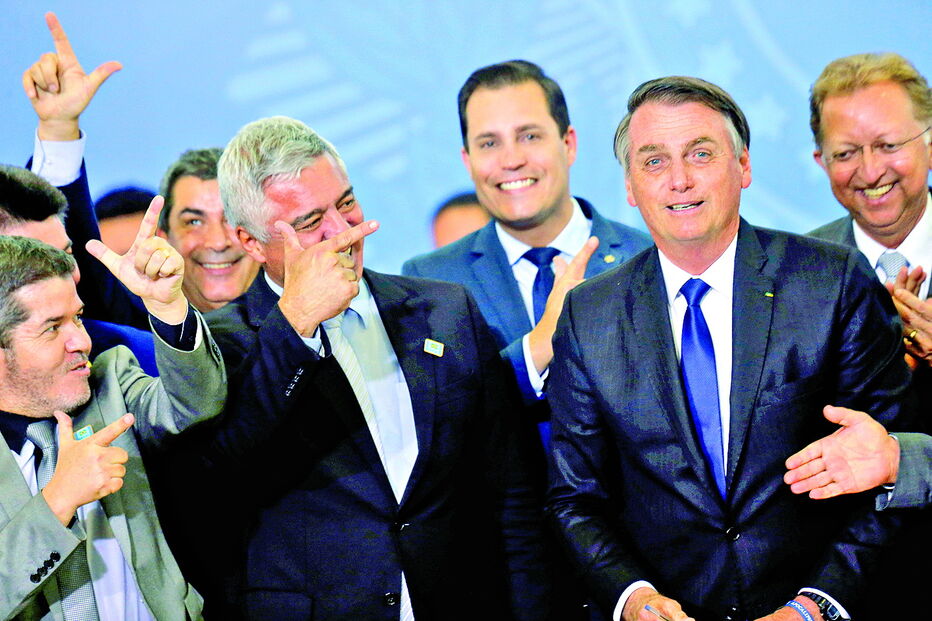 Bolsonaro saudado por congressistas durante a assinatura do novo decreto 