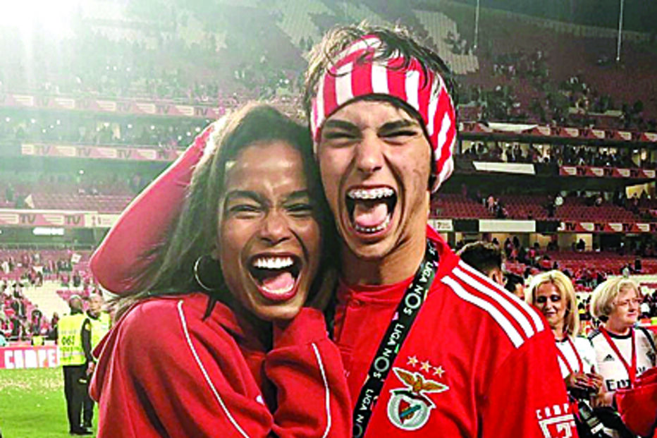 Rúben Dias e a namorada, April Ivy, posam com o troféu de campeão