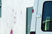 Marcas de sangue visíveis numa parede e numa carrinha