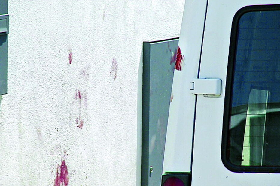 Marcas de sangue visíveis numa parede e numa carrinha