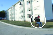 Traficante sentado numa cadeira controla negócio no bairro Pinheiro Torres