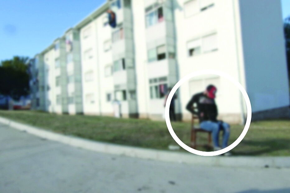 Traficante sentado numa cadeira controla negócio no bairro Pinheiro Torres