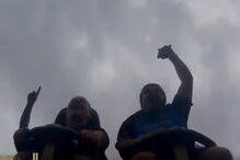 Homem apanhar telemóvel no ar em montanha-russa