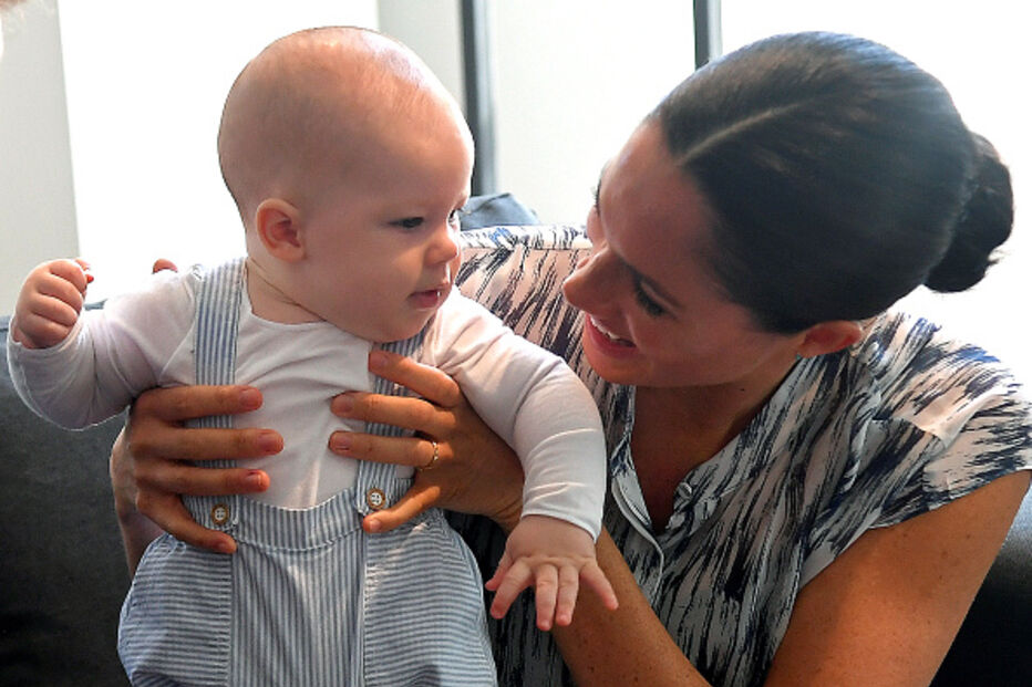 Archie sorridente no primeiro ato oficial ao lado de Meghan e Harry