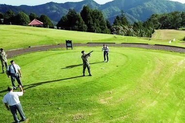 Miltar fardado dispara uma rajada de G3 no campo de golfe 