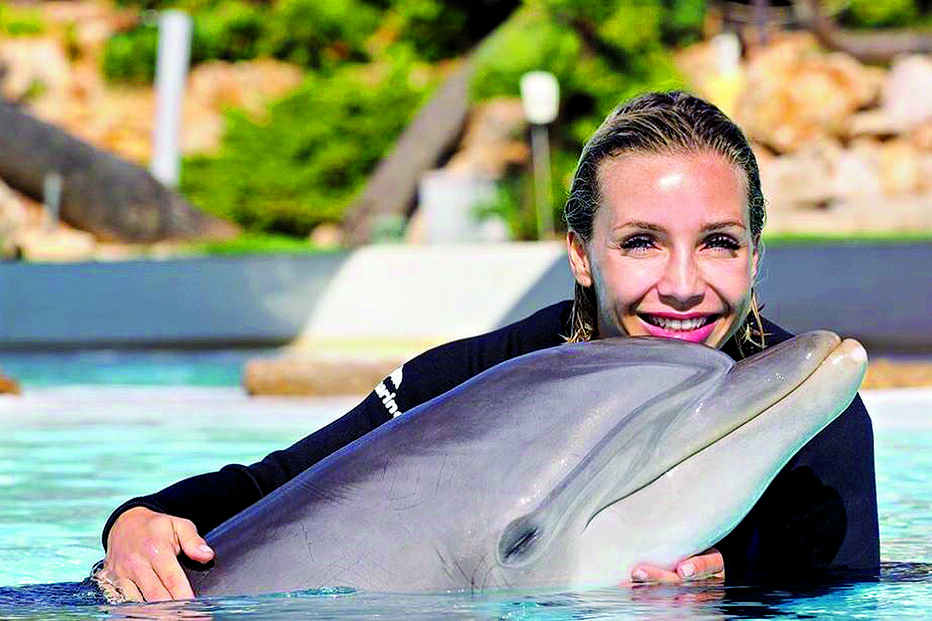 Atriz radiante com os golfinhos  