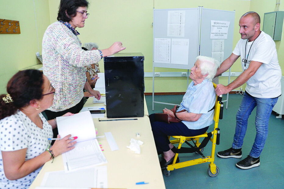 Eleitora com dificuldades de locomoção vota acompanhada, em Lisboa