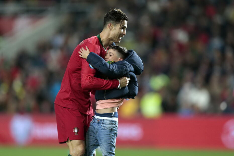 Homem e criança invadem relvado e conquistam abraço de Cristiano Ronaldo