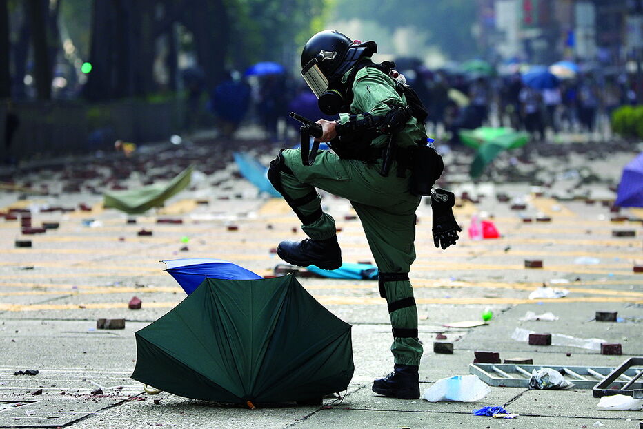 Polícia esmaga um guarda-chuva, símbolo do movimento pró-democracia 
