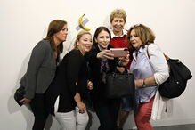 Várias pessoas posam com a obra de arte 'Comediante'