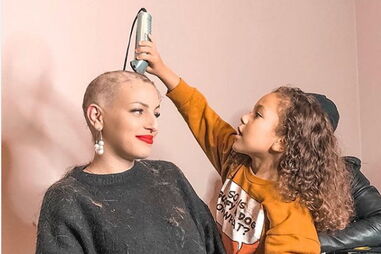 Lara e o filho Enzo, no momento em que o menino está a cortar o cabelo à mãe