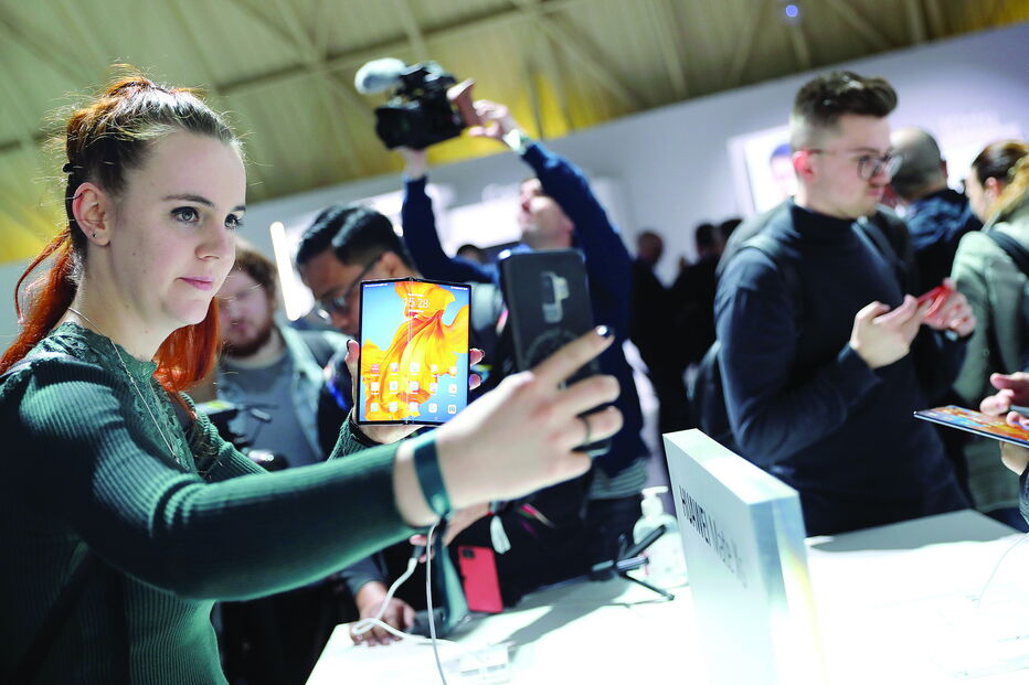 Consumidores testam o novo smartphone dobrável da Huawei. Tecnológica chinesa tenta travar queda nas vendas