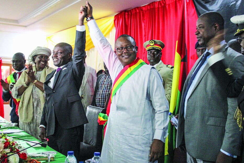 Umaro Sissoco Embaló, autoproclamado presidente da Guiné-Bissau (de camisa branca com a faixa presidencial) celebra com Nuno Nabian, primeiro-ministro