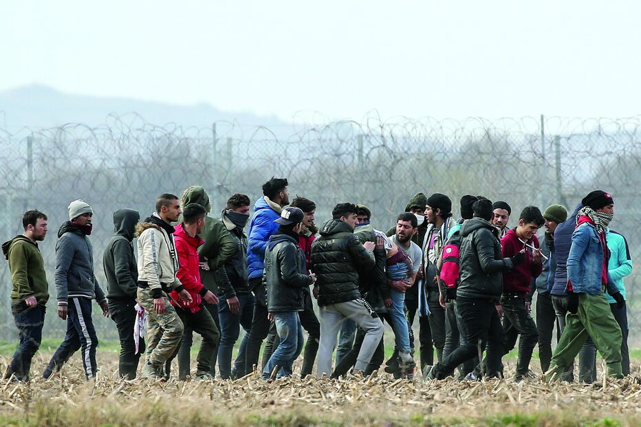 Refugiados transportam uma pessoa ferida nos confrontos junto à fronteira grega, onde foram recebidos com gás lacrimogéneo e canhões de água 