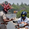 Polícia indiana equipada com capacetes de coronavírus pune infratores com métodos incomuns